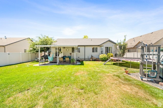 1458 N 2400 W, Clinton, UT 84015 - rear view of house featuring a trampoline, a patio area, and a fenced backyard