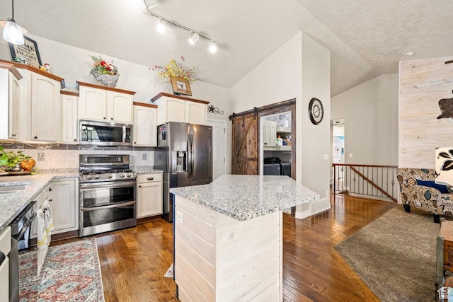 1458 N 2400 W, Clinton, UT 84015 - kitchen featuring separate washer and dryer, track lighting, vaulted ceiling, appliances with stainless steel finishes, and backsplash