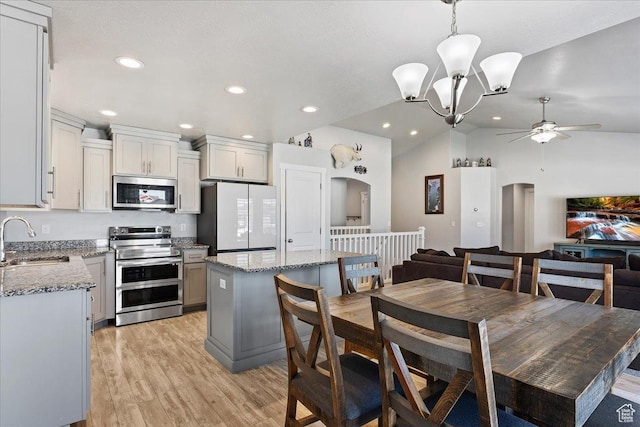 4448 W 5325 S, Hooper, UT 84315 - dining area featuring ceiling fan, arched walkways, light wood-type flooring, vaulted ceiling, and a chandelier