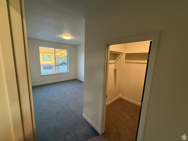 652 E 12225 S Unit 38, Draper, UT 84020 - unfurnished bedroom featuring dark carpet, a textured ceiling, and a walk in closet