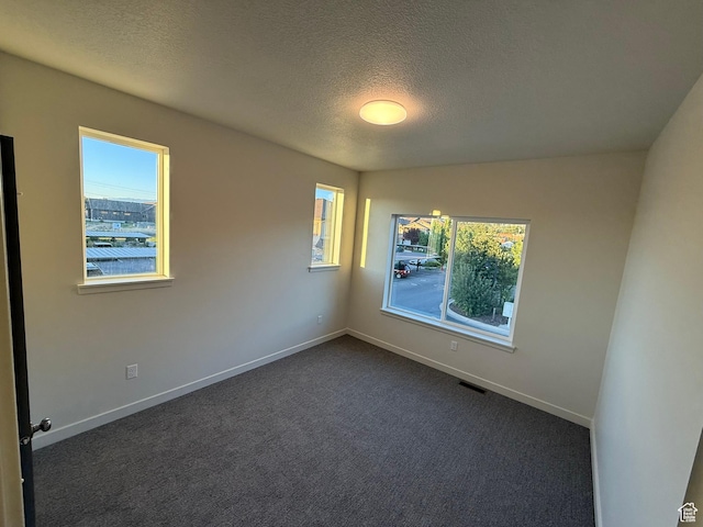 652 E 12225 S Unit 38, Draper, UT 84020 - spare room featuring a textured ceiling and dark colored carpet