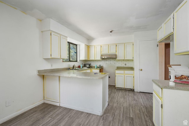 1469 E Winterwood Cir, Sandy, UT 84092 - kitchen featuring a peninsula, wood finished floors, backsplash, light countertops, and under cabinet range hood
