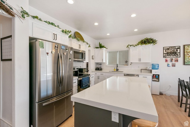 7310 N Green Pasture Ln, Eagle Mountain, UT 84005 - kitchen with appliances with stainless steel finishes, recessed lighting, light wood-style flooring, white cabinets, and light countertops