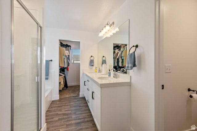 7310 N Green Pasture Ln, Eagle Mountain, UT 84005 - bathroom featuring a spacious closet, a shower stall, wood finished floors, and double vanity