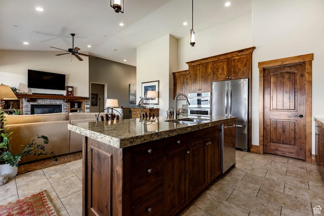 1658 E Viewside Cir, Hideout, UT 84036 - kitchen featuring high vaulted ceiling, ceiling fan, a stone fireplace, appliances with stainless steel finishes, and an island with sink