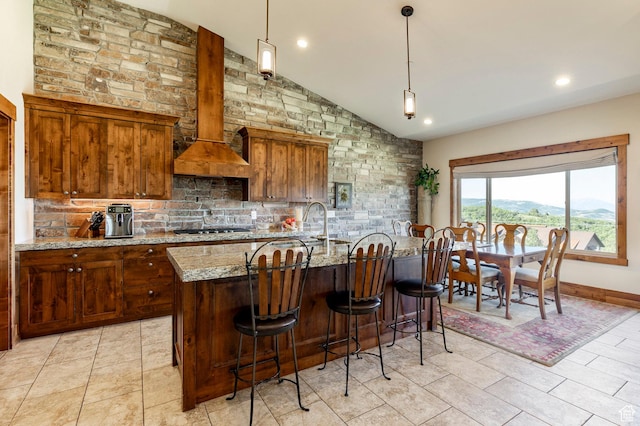 1658 E Viewside Cir, Hideout, UT 84036 - kitchen with vaulted ceiling, backsplash, light stone counters, a breakfast bar area, and pendant lighting
