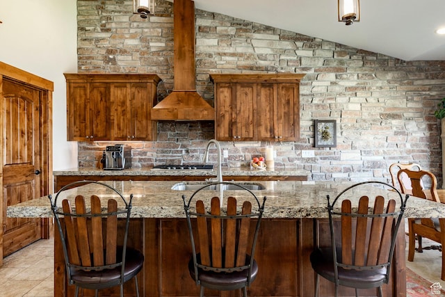 1658 E Viewside Cir, Hideout, UT 84036 - kitchen with vaulted ceiling, light stone countertops, decorative backsplash, a breakfast bar, and brown cabinets