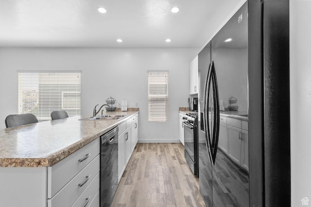 14764 S Rising Star Way W, Bluffdale, UT 84065 - kitchen featuring black appliances, a peninsula, light wood-type flooring, recessed lighting, and light countertops