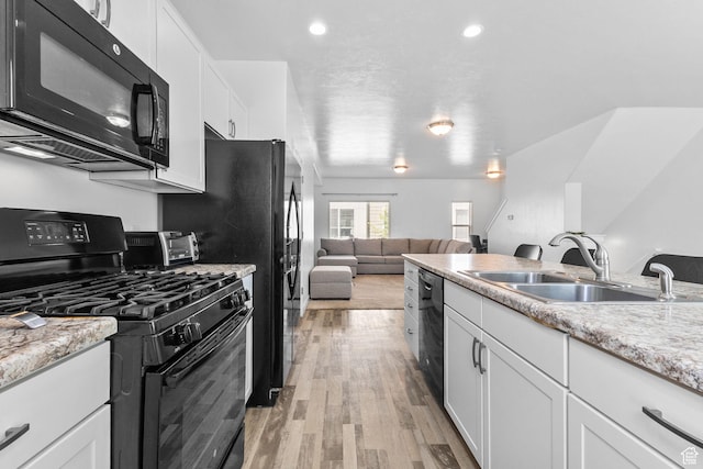 14764 S Rising Star Way W, Bluffdale, UT 84065 - kitchen with black appliances, white cabinets, light wood-style flooring, open floor plan, and light stone countertops