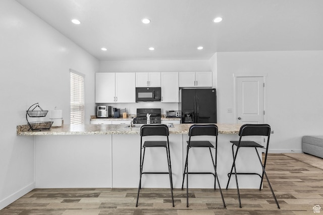 14764 S Rising Star Way W, Bluffdale, UT 84065 - kitchen with black appliances, white cabinets, light stone counters, a kitchen breakfast bar, and recessed lighting