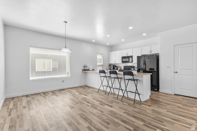 14764 S Rising Star Way W, Bluffdale, UT 84065 - kitchen with light wood-type flooring, black appliances, a peninsula, white cabinetry, and a breakfast bar area