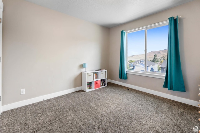 3973 E Eagle Top Ct, Eagle Mountain, UT 84005 - carpeted empty room featuring baseboards and a mountain view
