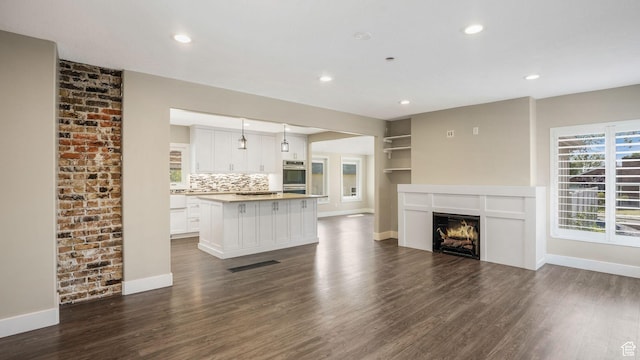 5398 S 2300 W, Roy, UT 84067 - unfurnished living room featuring dark wood-type flooring, recessed lighting, and a lit fireplace
