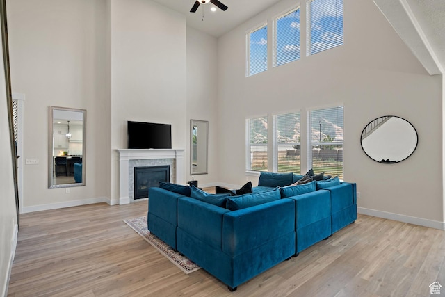 3056 E 80 S, Spanish Fork, UT 84660 - living room featuring a ceiling fan, a high ceiling, light wood-style floors, and a glass covered fireplace