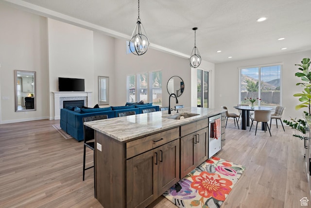 3056 E 80 S, Spanish Fork, UT 84660 - kitchen with light wood-style flooring, light stone counters, decorative light fixtures, a kitchen breakfast bar, and a kitchen island with sink