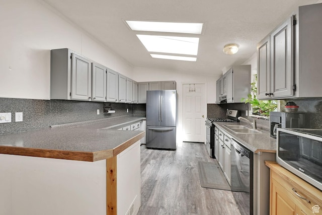 4171 W 2425 N, Hooper Davis Cnty, UT 84315 - kitchen featuring stainless steel appliances, backsplash, light wood-style flooring, vaulted ceiling, and a peninsula