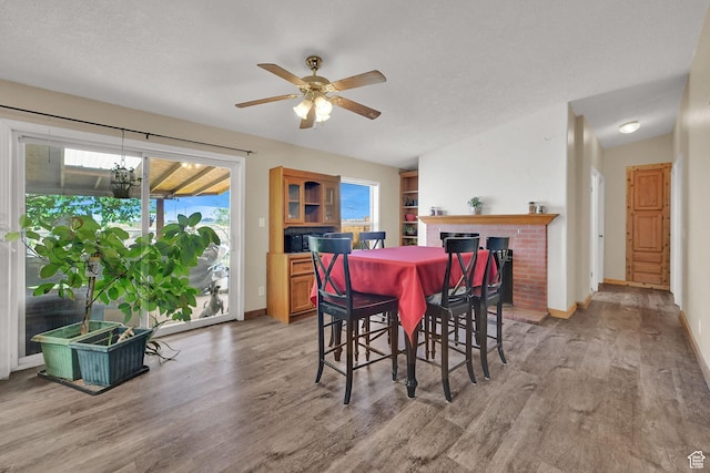 4171 W 2425 N, Hooper Davis Cnty, UT 84315 - dining area with light wood finished floors, ceiling fan, and a brick fireplace
