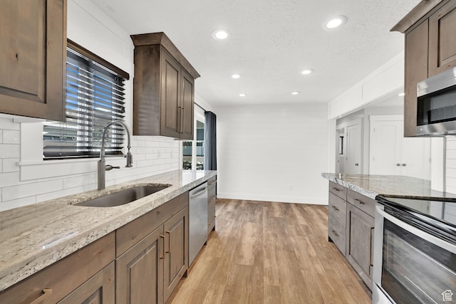 648 W Porter Ln, Centerville, UT 84014 - kitchen with appliances with stainless steel finishes, light stone countertops, recessed lighting, light wood-style floors, and backsplash