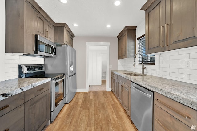 648 W Porter Ln, Centerville, UT 84014 - kitchen with stainless steel appliances, light wood finished floors, tasteful backsplash, recessed lighting, and light stone countertops