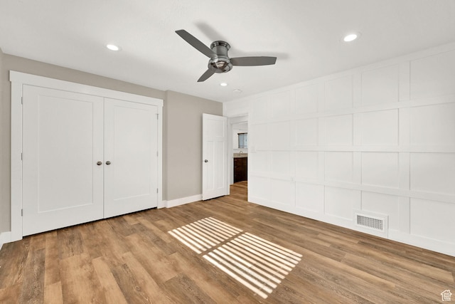 648 W Porter Ln, Centerville, UT 84014 - unfurnished bedroom with wood finished floors, recessed lighting, a ceiling fan, a closet, and a decorative wall