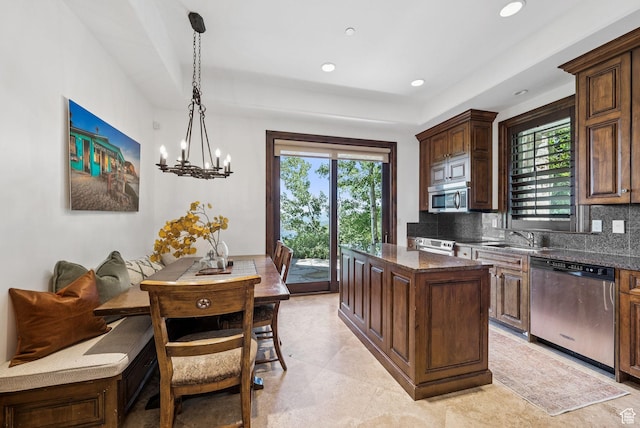 10399 Summit View Dr N, Park City, UT 84060 - kitchen with decorative backsplash, stainless steel appliances, a center island, decorative light fixtures, and dark stone counters