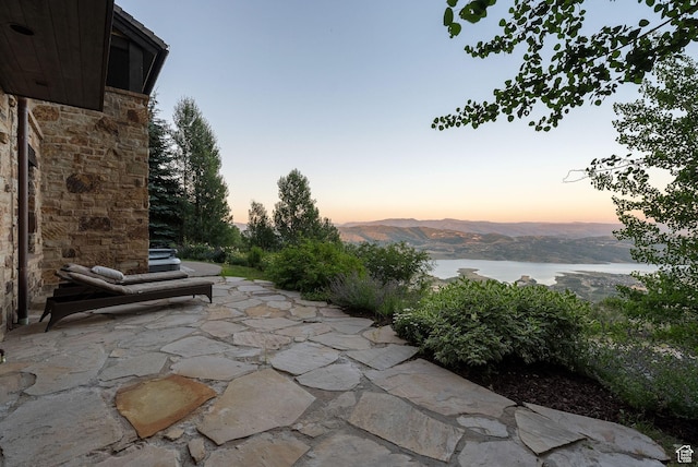 10399 Summit View Dr N, Park City, UT 84060 - patio terrace at dusk featuring a patio area and a water and mountain view
