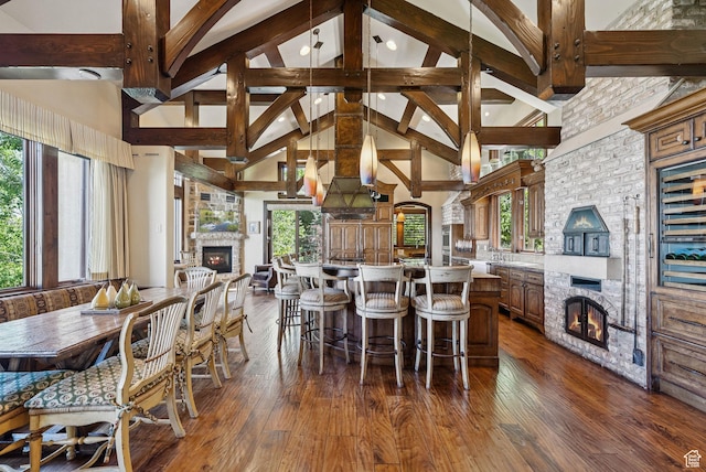 10399 Summit View Dr N, Park City, UT 84060 - dining space featuring a fireplace, high vaulted ceiling, dark wood-style flooring, beam ceiling, and wine cooler