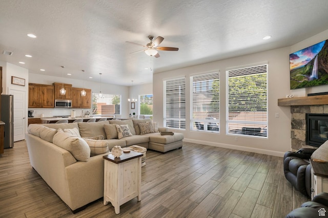 5336 W 3180 S, Hurricane, UT 84737 - living room featuring ceiling fan, recessed lighting, wood finished floors, a stone fireplace, and a chandelier