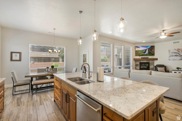 5336 W 3180 S, Hurricane, UT 84737 - kitchen featuring brown cabinetry, a glass covered fireplace, dishwasher, and ceiling fan