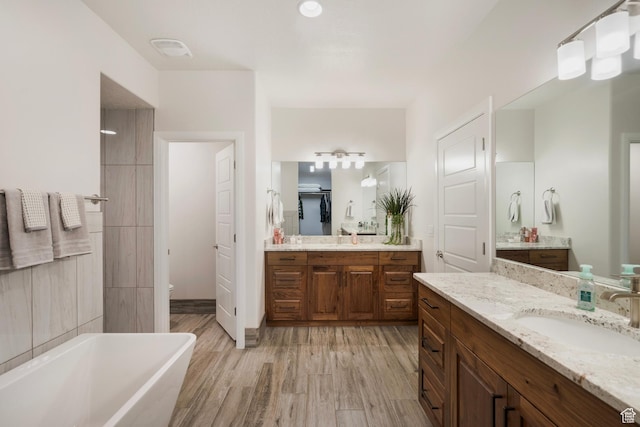5336 W 3180 S, Hurricane, UT 84737 - bathroom featuring a freestanding tub, two vanities, and wood finished floors