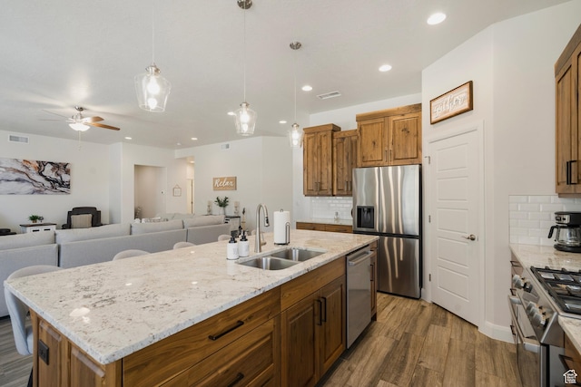 5336 W 3180 S, Hurricane, UT 84737 - kitchen featuring wood finished floors, stainless steel appliances, tasteful backsplash, brown cabinets, and recessed lighting