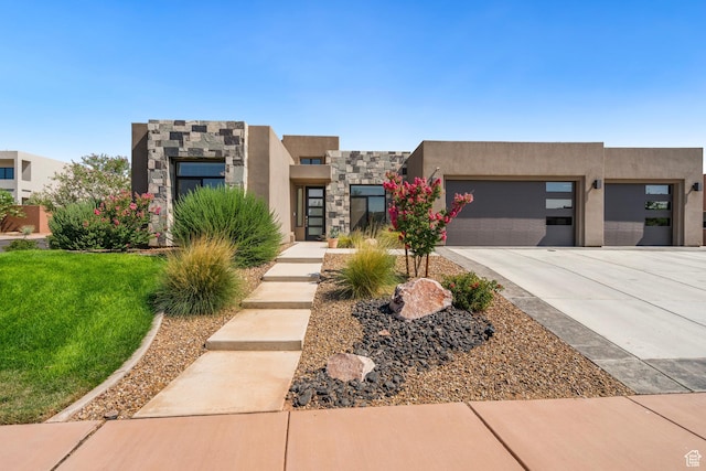 5336 W 3180 S, Hurricane, UT 84737 - view of front of house featuring concrete driveway, stone siding, an attached garage, and stucco siding