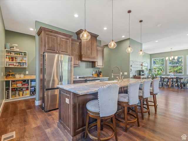 355 S 200 E, Bountiful, UT 84010 - kitchen with stainless steel appliances, light stone countertops, dark wood finished floors, a kitchen island with sink, and pendant lighting