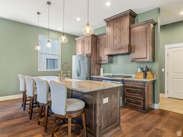 355 S 200 E, Bountiful, UT 84010 - kitchen with appliances with stainless steel finishes, dark wood finished floors, an island with sink, recessed lighting, and a kitchen bar