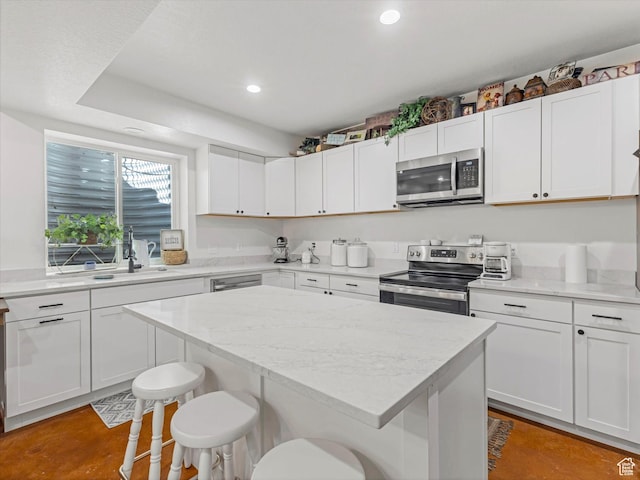 355 S 200 E, Bountiful, UT 84010 - kitchen with appliances with stainless steel finishes, a kitchen breakfast bar, a kitchen island, white cabinets, and recessed lighting