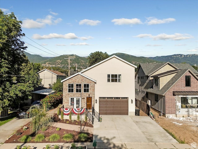 355 S 200 E, Bountiful, UT 84010 - view of front of home with concrete driveway, an attached garage, stone siding, a mountain view, and stucco siding