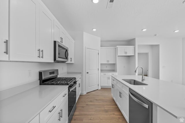 1391 S Padre Bay Dr Unit 4075, Washington, UT 84780 - kitchen with stainless steel appliances, white cabinetry, light countertops, light wood finished floors, and recessed lighting
