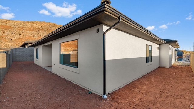 1391 S Padre Bay Dr Unit 4075, Washington, UT 84780 - view of side of home with stucco siding, a chimney, and a patio