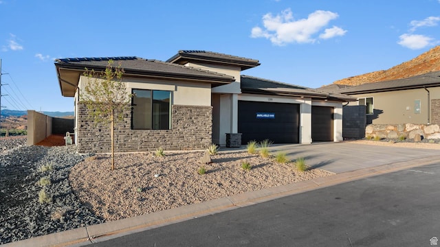 1391 S Padre Bay Dr Unit 4075, Washington, UT 84780 - prairie-style house featuring stone siding, driveway, an attached garage, a tile roof, and stucco siding