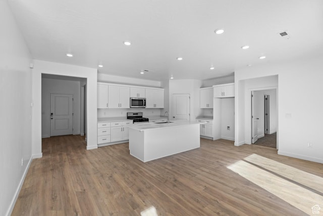 1391 S Padre Bay Dr Unit 4075, Washington, UT 84780 - kitchen with recessed lighting, white cabinetry, light wood finished floors, stainless steel appliances, and a kitchen island with sink
