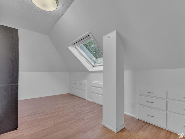 235 N 300 W, Smithfield, UT 84335 - additional living space with a skylight, wood finished floors, lofted ceiling, and a textured ceiling