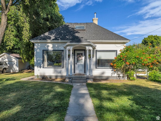 235 N 300 W, Smithfield, UT 84335 - view of front facade featuring a chimney, a front yard, and roof with shingles