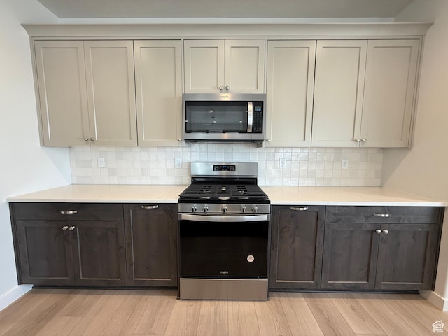 22 S 3830 W Unit 422, West Point, UT 84015 - kitchen featuring stainless steel appliances, light wood-type flooring, light countertops, and decorative backsplash