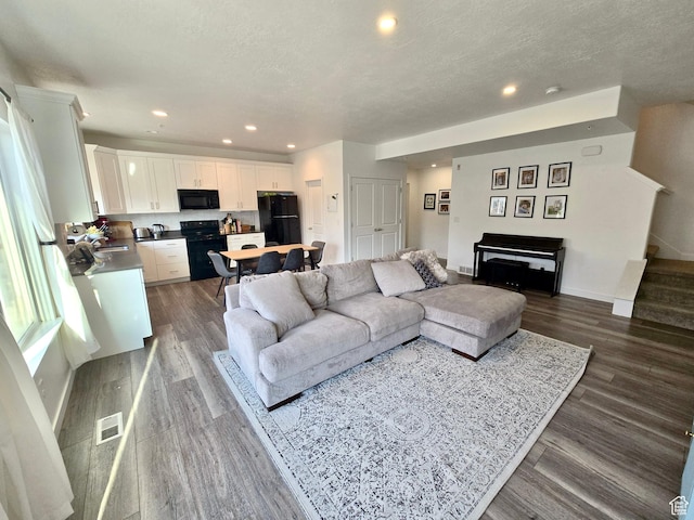 5381 W Mount Maclure Pl, Herriman, UT 84096 - living room with dark wood-style flooring, recessed lighting, stairs, and a textured ceiling