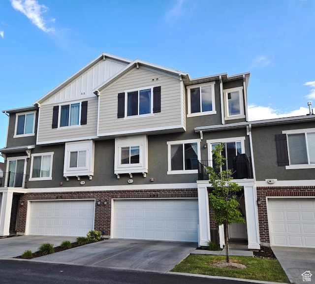 5381 W Mount Maclure Pl, Herriman, UT 84096 - view of front of property featuring an attached garage, brick siding, driveway, and stucco siding