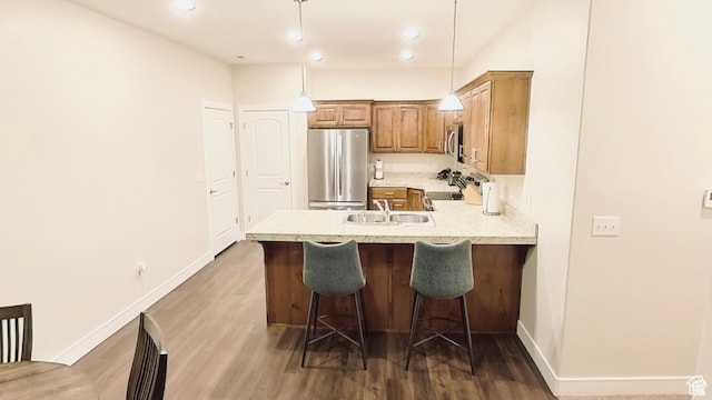 1768 W 300 S Unit D, Springville, UT 84664 - kitchen featuring a peninsula, stainless steel appliances, a breakfast bar area, dark wood finished floors, and light countertops
