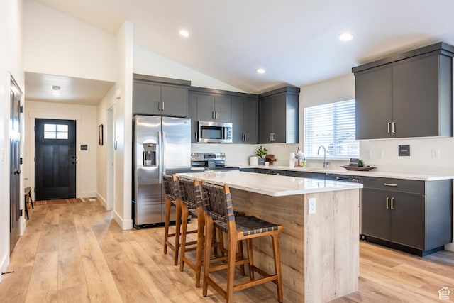160 S 940 E, Santaquin, UT 84655 - kitchen with appliances with stainless steel finishes, a center island, a breakfast bar, light wood finished floors, and vaulted ceiling