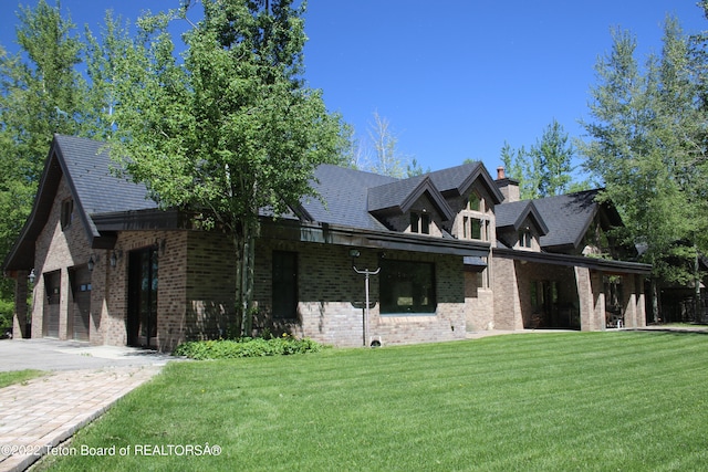 view of side of property featuring a garage and a yard