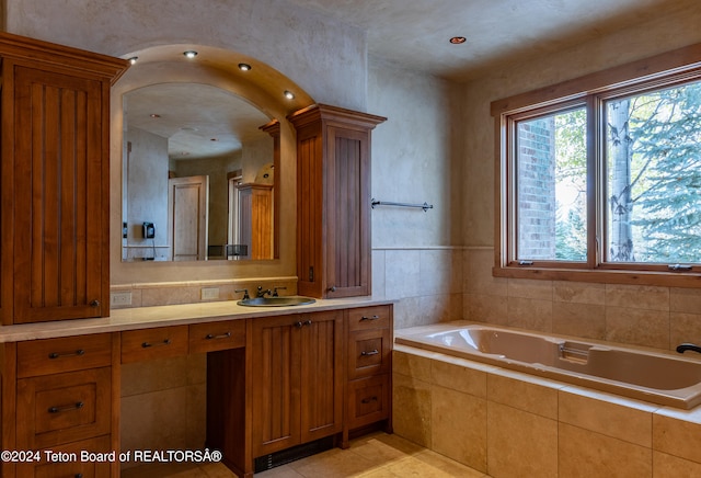 bathroom with vanity, tiled bath, and tile patterned floors