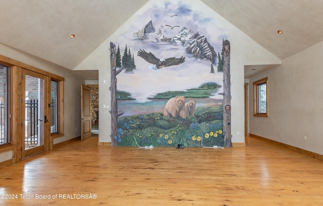 entrance foyer with light hardwood / wood-style floors and high vaulted ceiling